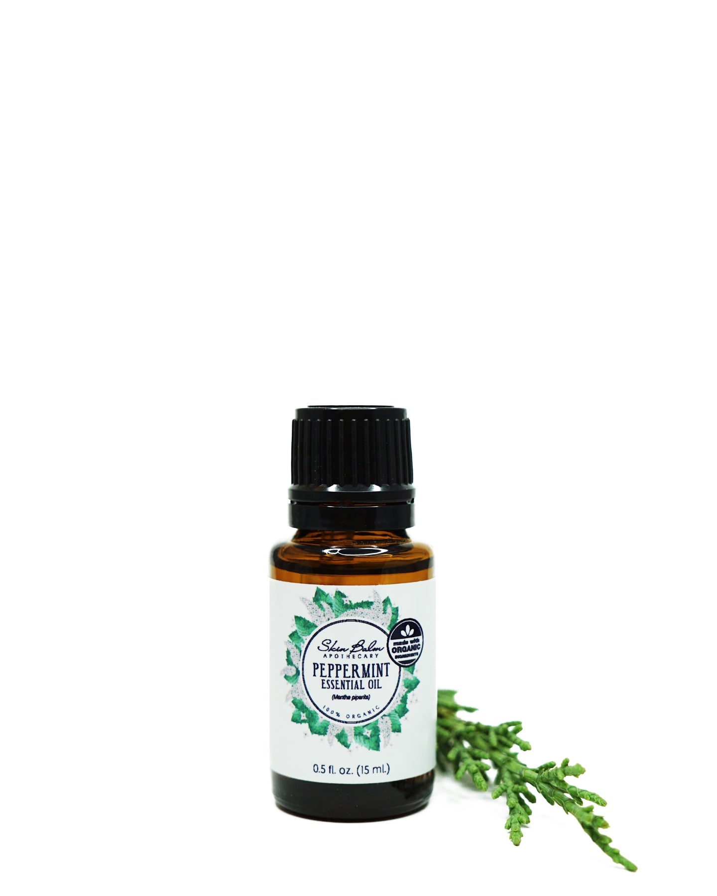 Organic Peppermint Essential Oil with green foliage against a white background.