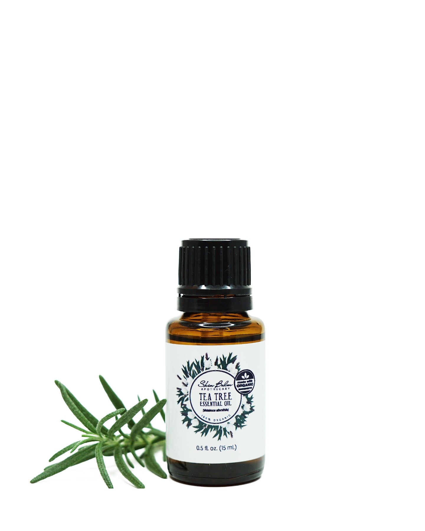Organic Tea Tree Essential Oil with green foliage against a white background.