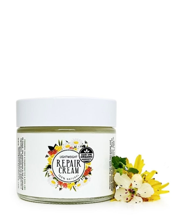 Repair Cream with white and yellow flowers against a white background.